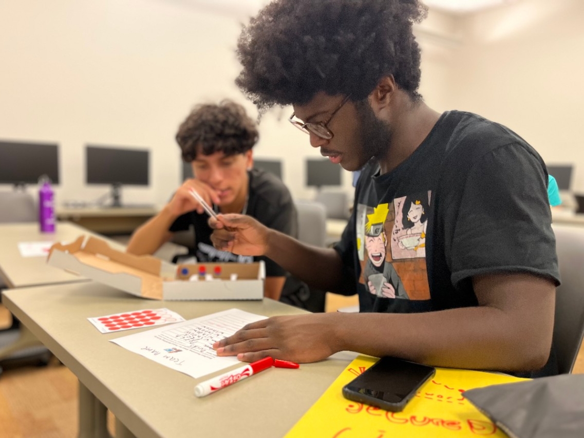 Two high school students doing a hands on simulation of cybersecurity protection planning